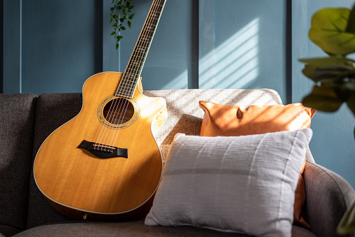 Acoustic guitar on a stylish sofa in natural light