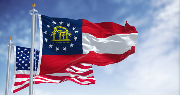 The Georgia state flag waving along with the national flag of the United States of America The Georgia state flag waving along with the national flag of the United States of America. In the background there is a clear sky. georgia flag country stock pictures, royalty-free photos & images