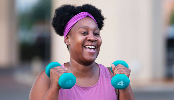istock African-American woman exercising with dumbbells 1390921576