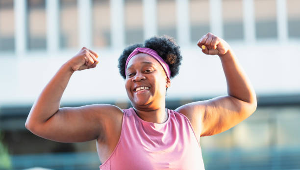 istock African-American woman flexing muscles 1390921579