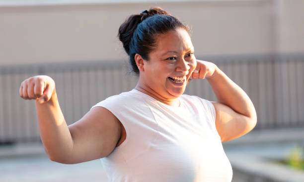 istock Pacific Islander woman flexing her biceps, laughing 1390921602