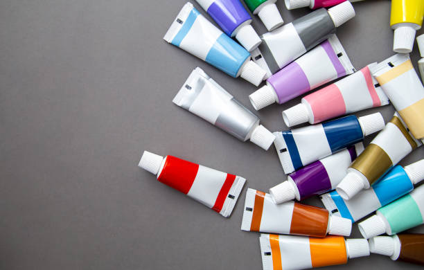 Tubes of acrylic paint in different colors, flat lay. Tubes with acrylic paint in different colors on grey background, the concept of creativity, drawing and art. acrylic painting stock pictures, royalty-free photos & images