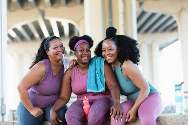 Three multiracial women sit together after workout