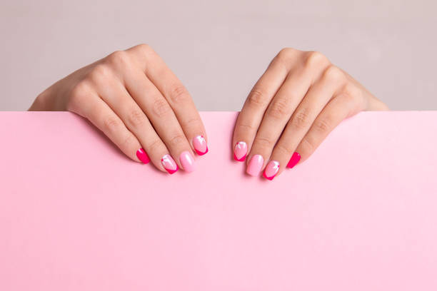 istock Female hands with pink manicure nails 1390925215