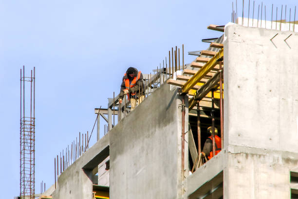 trabajadores con chalecos brillantes durante la construcción de un edificio de apartamentos monolítico - procession panel fotografías e imágenes de stock