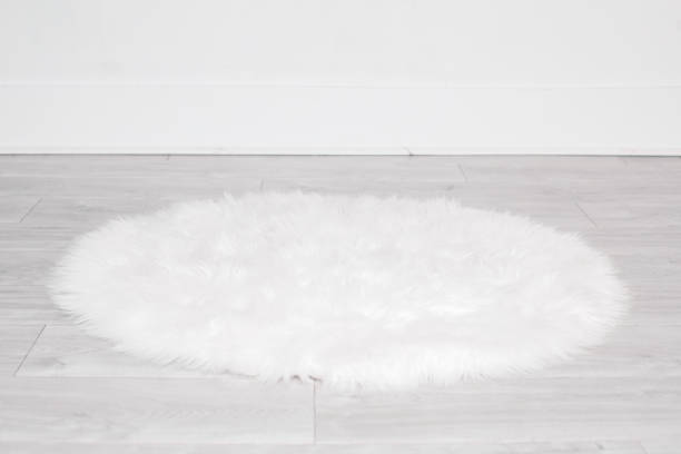 istock White round fluffy rug carpet lying on floor by white wall at home. Background mockup for designs and backdrop 1390942871