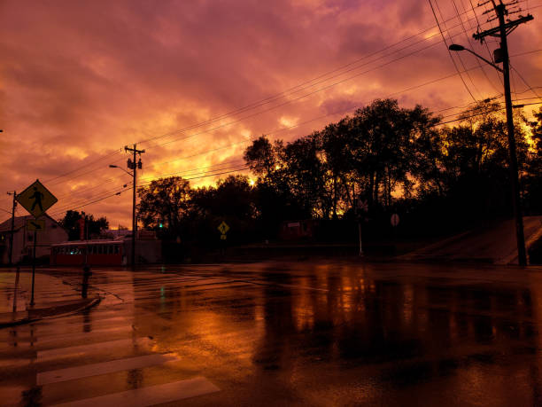 Sepia sunset in Harrisonburg, VA on a street Corner in town. Road is wet from recent rain and sky is filled with clouds. Photo is unfiltered.