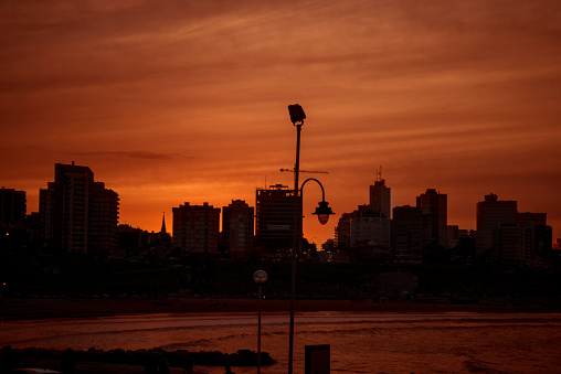 sunset in the city, you see the red sky, crane, lamp and the sea ahead