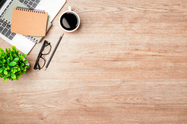 istock Work from home. desk office with laptop, blank notepad, coffee cup and pen on wood table. Flat lay top view copy spce. 1390949339