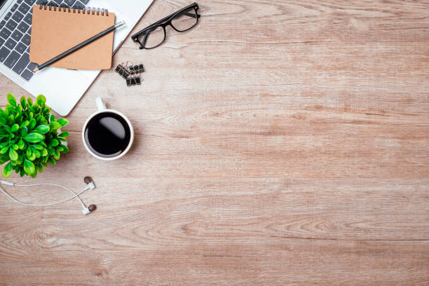 istock Work from home. desk office with laptop, blank notepad, coffee cup and pen on wood table. Flat lay top view copy spce. 1390949343