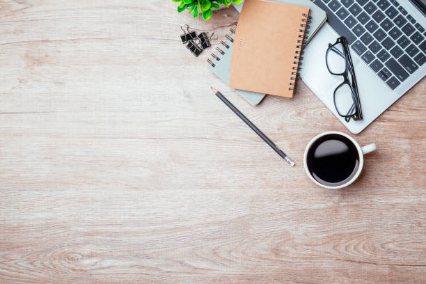 Work from home. desk office with laptop, blank notepad, coffee cup and pen on wood table. Flat lay top view copy spce.