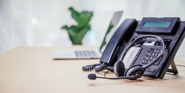 istock Communication support, call center and customer service help desk. telephone devices with VOIP headset in office.Customer service support (call center) concept. 1390949361