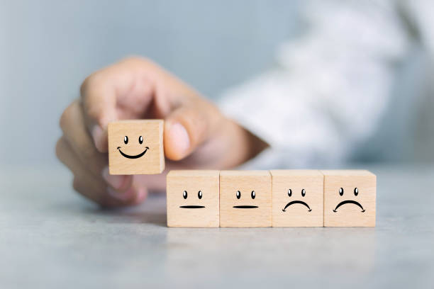 istock Close up customer hand choose smiley face icon on wood cube, Service rating, satisfaction concept. 1390949377