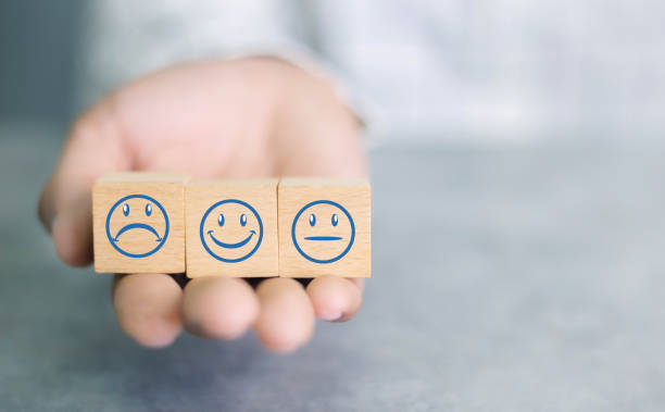 istock Close up customer hand choose smiley face icon on wood cube, Service rating, satisfaction concept. 1390949379