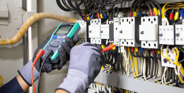 istock Electrician engineer tests electrical installations and wires on relay protection system. Adjustment of scheme of automation and control of electrical equipment. 1390949495