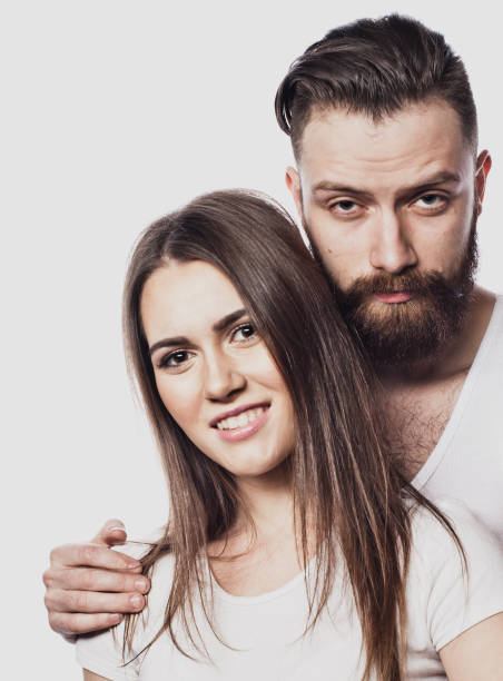 istock Happy couple embracing and looking camera on white background 1390949566