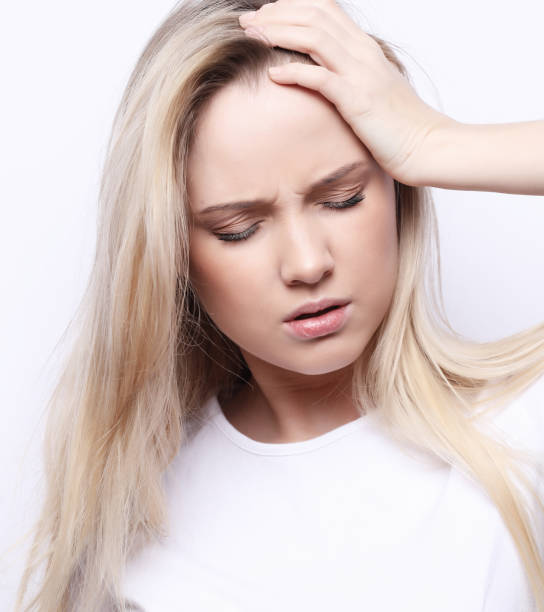 istock Young woman has headache, over white background 1390950397
