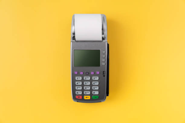 istock Card reader machine with invoice bill on yellow background. Online payment concept. 1390951480