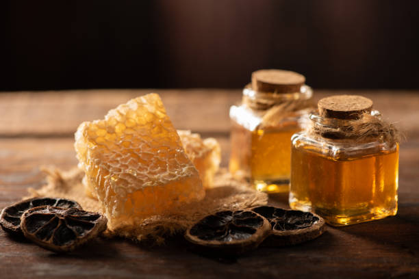 istock Homemade honey jar with honeycomb on a rustic wooden table 1390968174