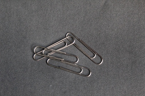 several pieces of paper clips on a black background