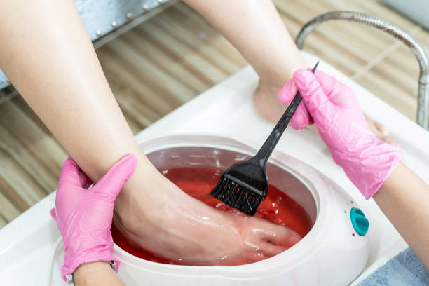 Woman making a foot paraffin spa. stock photo