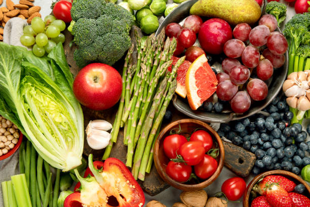 istock Delicious raw fruits and vegetables on light background. 1390970533