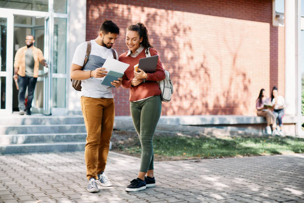 istock Happy college friends going through lecture notes together at campus. 1390974903
