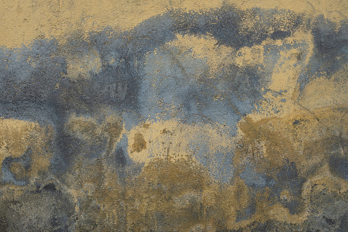 A vintage grunge background with patina-like colors, cracks, and golden brown and yellow paper textures.. Copy space