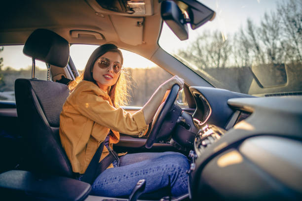 istock Young woman driving car on a sunny day 1390975346