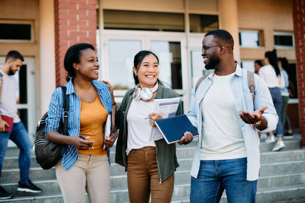 Multiracial group of happy students talking and having fun after the lecture at campus. stock photo