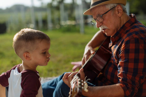 istock Watching grandpa play guitar 1390976385