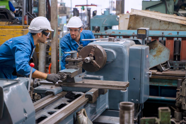 istock Blue collar worker with co worker at factory. 1390976505