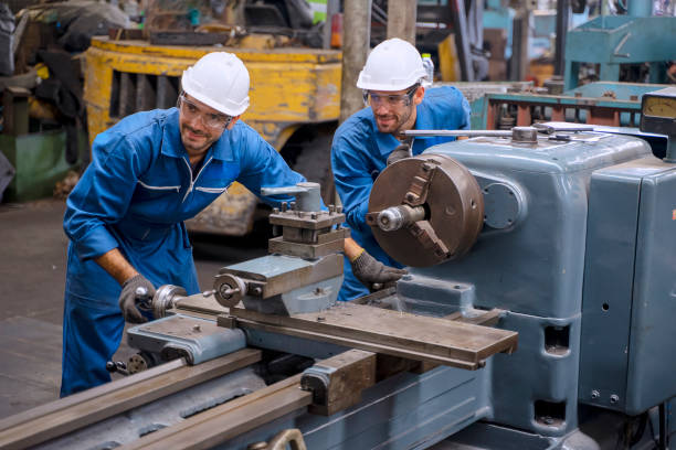 istock Blue collar worker with co worker at factory. 1390976583