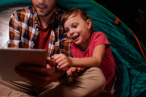 istock Smiling girl and dad use tablet 1390976619