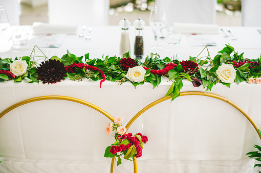 Wedding decorated table with two metal circles and red flowers and roses
