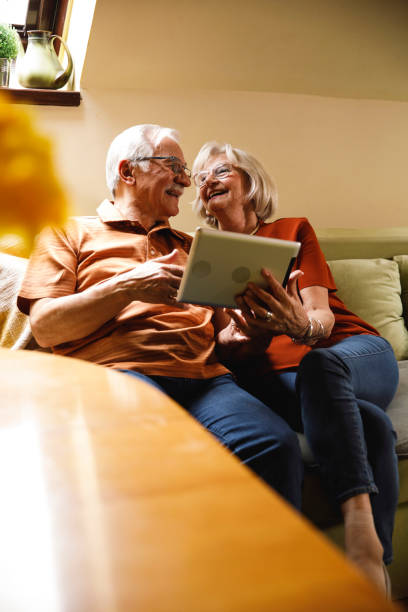 istock Happy senior couple having a bonding moment while using digital tablet and relaxing 1390979429