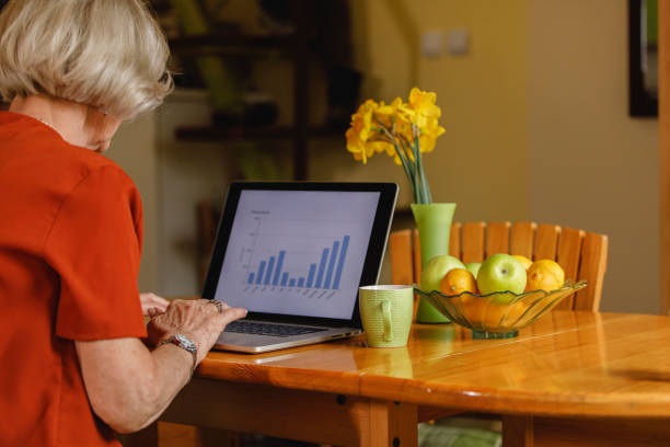 istock Senior woman working out her finances on laptop while having coffee 1390980202