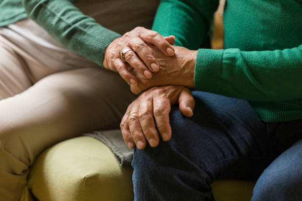 istock Midsection of unrecognizable elderly couple holding hands while relaxing 1390980359