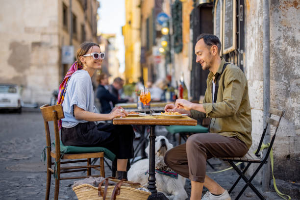 ローマの路上のレストランでイタリアンパスタを食べる女性 - holidays and food ストックフォトと画像