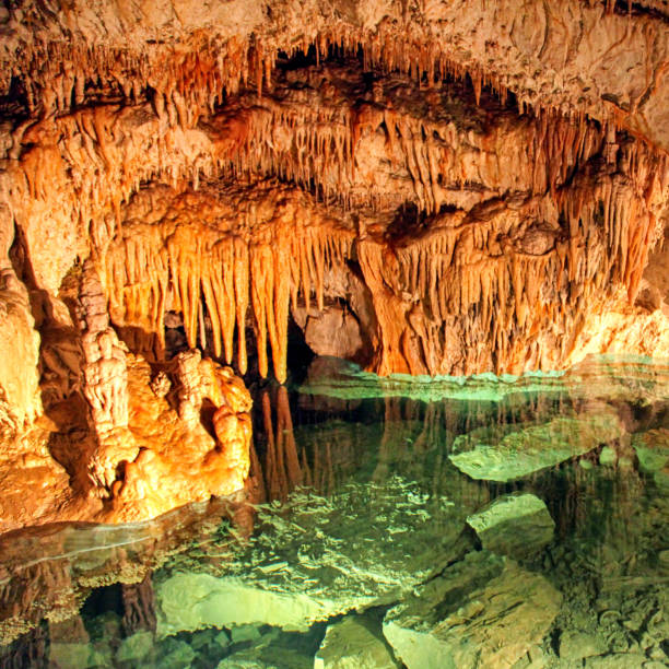 Colorful lake and stalactites and stalagmites in the cave called Demanovska cave of liberty in Slovakia stock photo