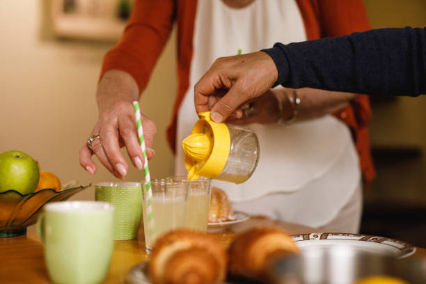 istock Senior man pouring fresh lemonade into drinking glasses, wife adding drinking straws 1390981253