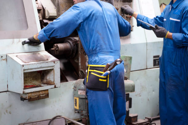 istock Blue collar worker with co worker at factory. 1390981328