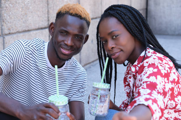 istock Young african couple taking a selfie, drinking refreshments. 1390981467