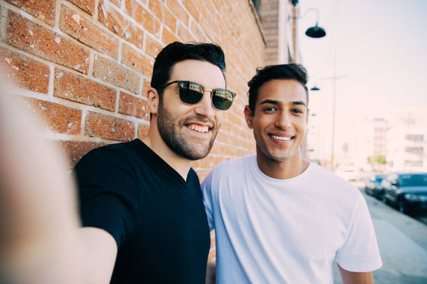 istock Men couple posing for a street selfie 1390981555