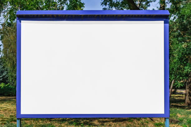 istock Old metal billboard with blank white frame for text in city park 1390981682