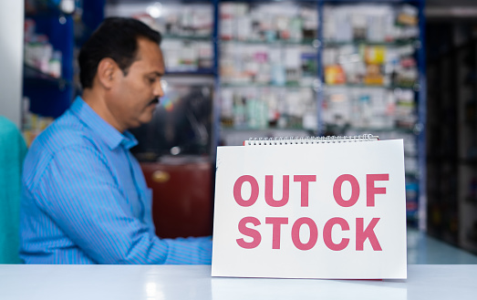 Out of stock sign board placed in front of medical or pharma store counter - concept of sold out and increase in demand of medicines
