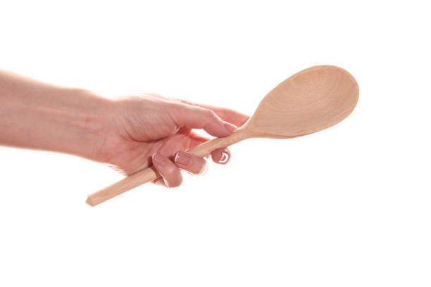 istock Female hand with a wooden spoon 1390982851