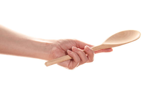 istock Female hand with a wooden spoon 1390982855
