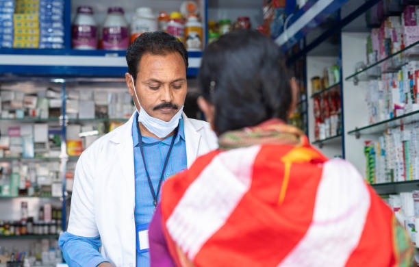 istock woman purchasing medicines at pharmacy store while pharmacist wearing mask below face - concept of healthcare, improper mask wear and covid-19 coronavirus protection. 1390982949