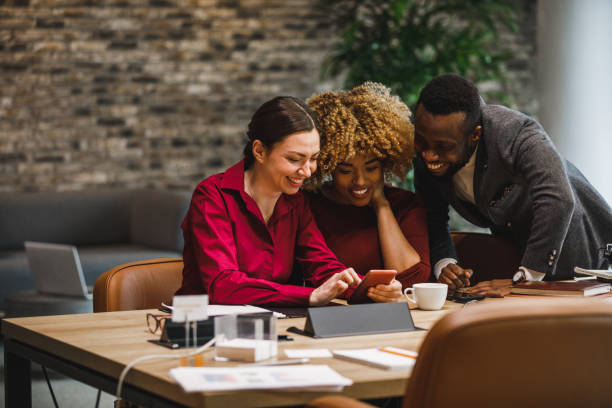 istock Three diverse business colleagues looking at funny memes during coffee break 1390983722